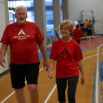 Programme Above + Beyond Cancer Walk With Ease montrant un homme et une femme marchant sur une piste.