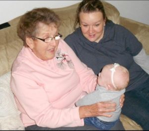 Abby and her grandma, holding a baby.