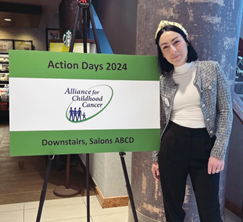 Natalie poses by a sign for Alliance for Childhood Cancer Action Days 2024 in Washington, DC.